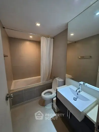 Modern bathroom with sleek fixtures and a bathtub in a contemporary apartment.