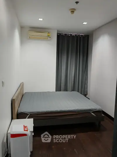 Cozy bedroom with minimalist decor and air conditioning, perfect for a restful retreat.