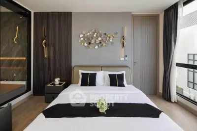 Modern bedroom with stylish decor and large window offering natural light