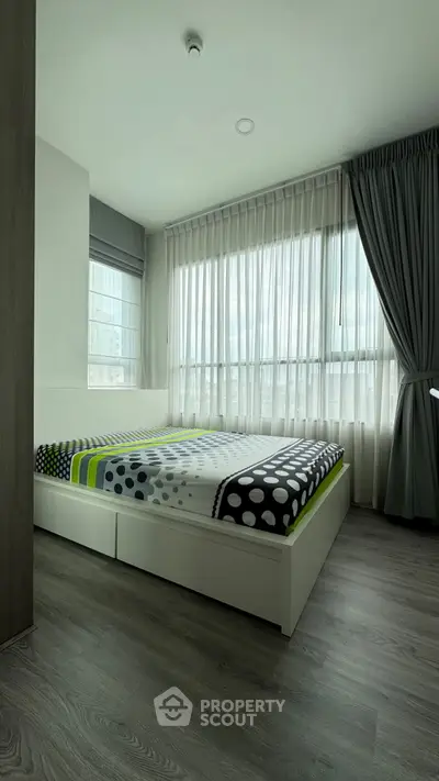 Modern bedroom with stylish decor and large windows for natural light.