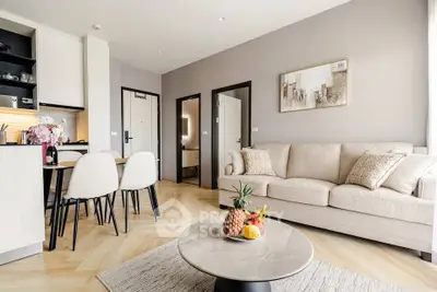 Modern living room with elegant decor and open kitchen layout, featuring a cozy sofa and stylish dining area.