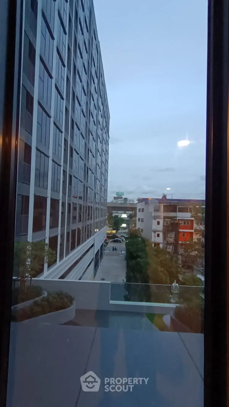 Stunning urban view from a modern high-rise building balcony at sunset.