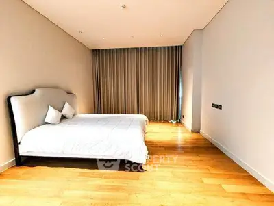 Spacious modern bedroom with elegant decor and wooden flooring