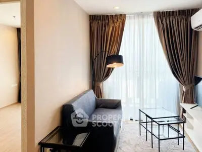 Modern living room with elegant decor and large window offering natural light.