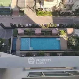 Stunning aerial view of modern apartment complex with luxurious swimming pool and lush greenery.