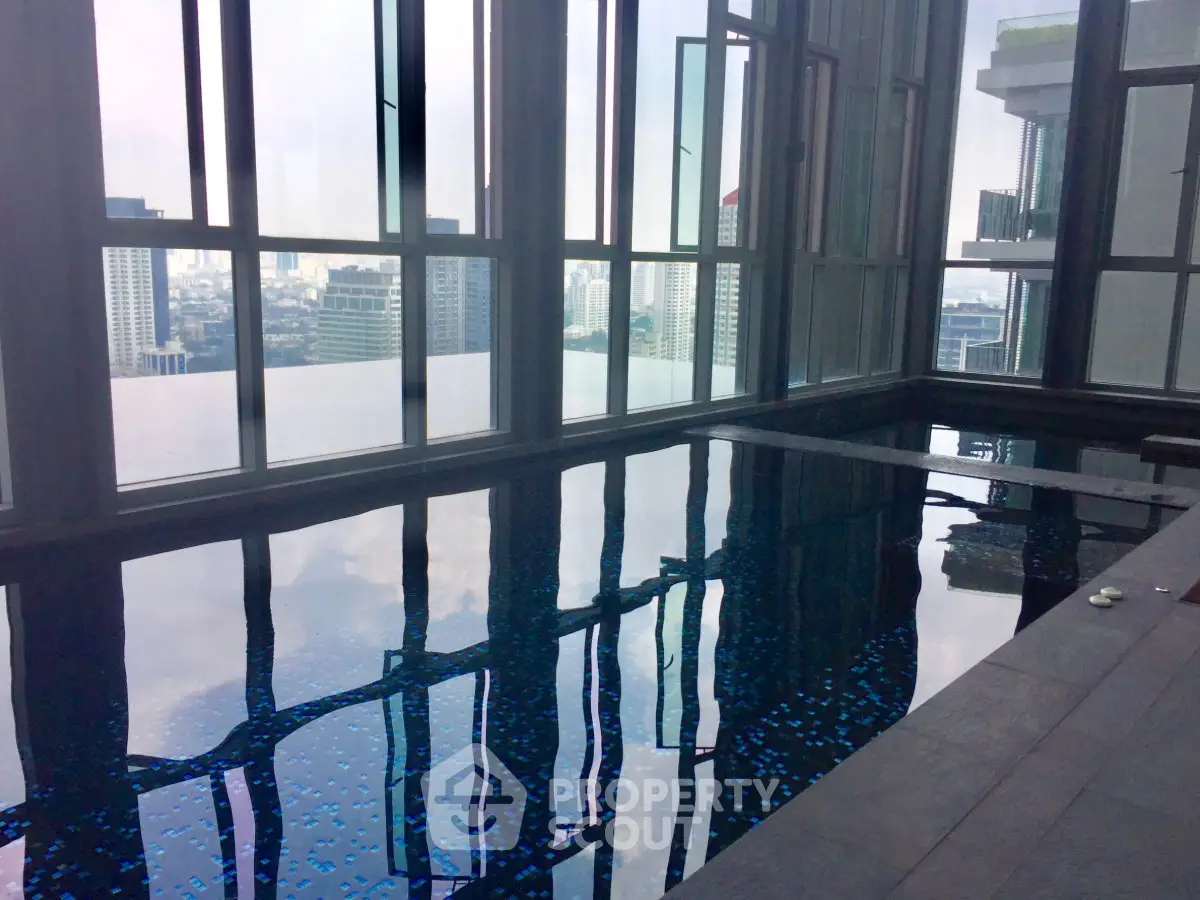 Luxurious indoor pool with stunning city skyline views in a high-rise building.