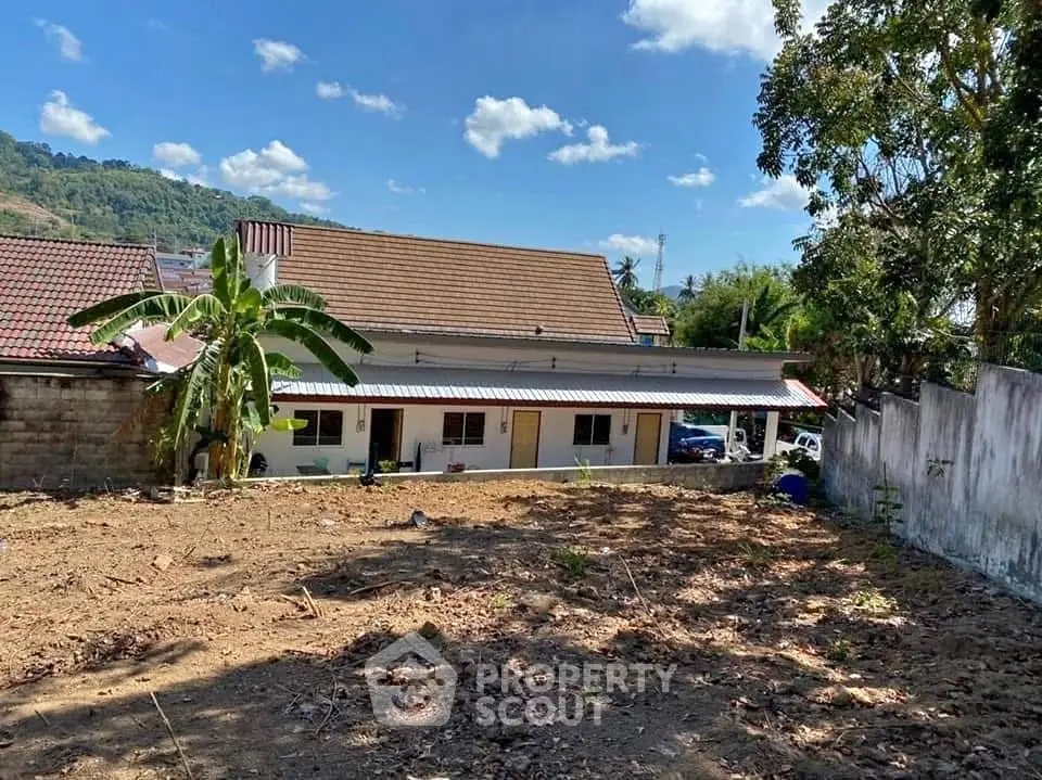 Charming single-story house with spacious yard and scenic mountain backdrop.