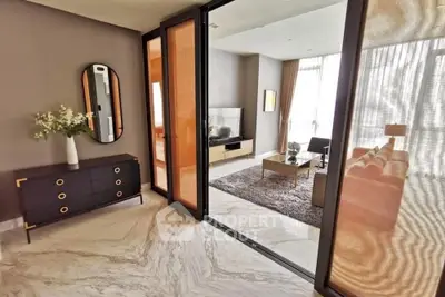 Elegant living room with modern decor and marble flooring, featuring a cozy seating area and stylish furniture.