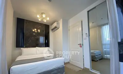 Modern bedroom with stylish lighting and mirrored closet in cozy apartment.