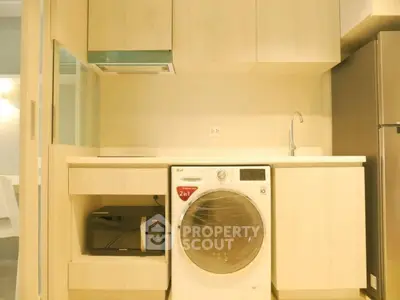 Compact modern kitchen with built-in appliances and ample storage space, featuring a convenient washing machine and sleek cabinetry.
