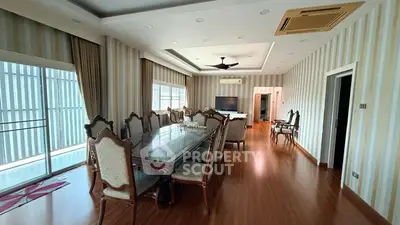 Spacious dining room with elegant wooden furniture and large windows for natural light.