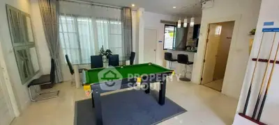 Stylish modern living room with pool table and open kitchen layout