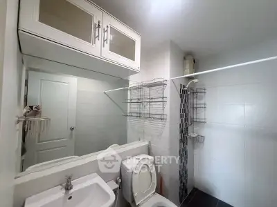 Modern bathroom with shower and storage cabinets in a sleek apartment.