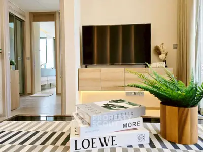 Modern living room with stylish decor and flat-screen TV, featuring a cozy ambiance.