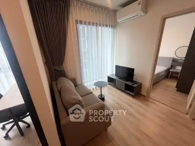 Modern living room with cozy sofa, TV, and natural light from large window in stylish apartment.