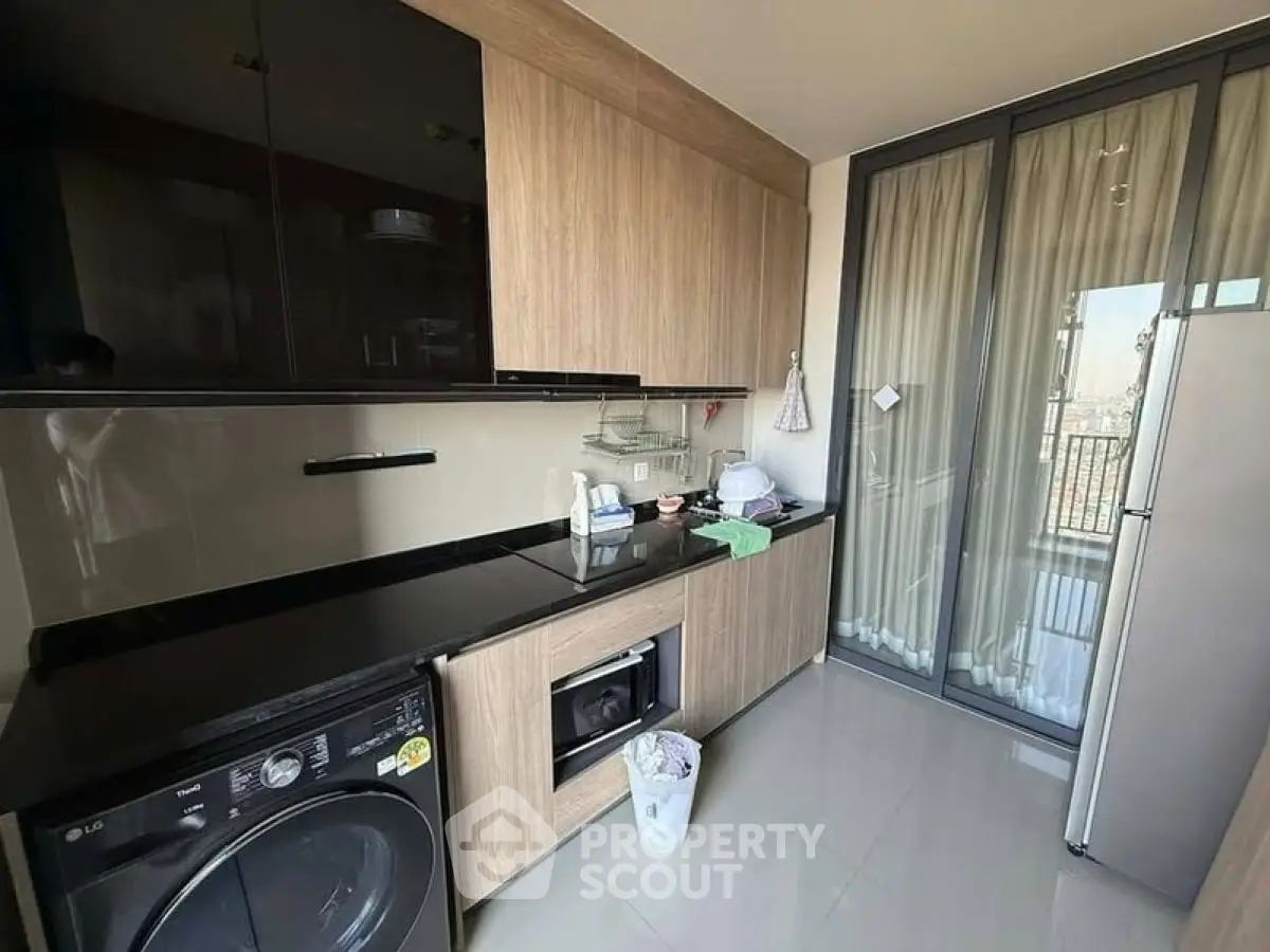 Modern kitchen with sleek cabinetry, built-in appliances, and balcony access.