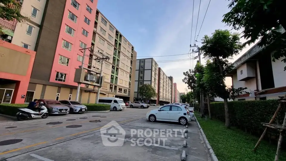 Modern apartment complex with ample parking and lush greenery