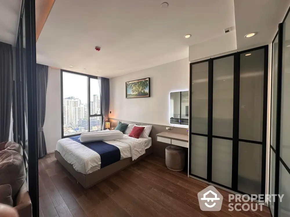 Modern bedroom with city view, featuring stylish decor and ample natural light.