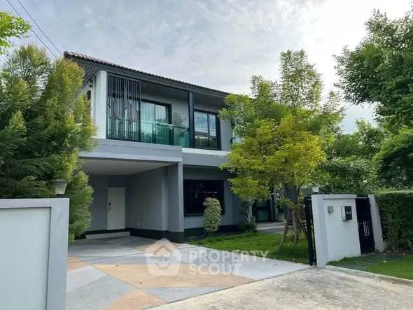 Modern two-story house with lush greenery and spacious driveway