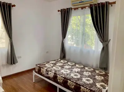 Cozy bedroom with natural light and elegant curtains, perfect for relaxation.