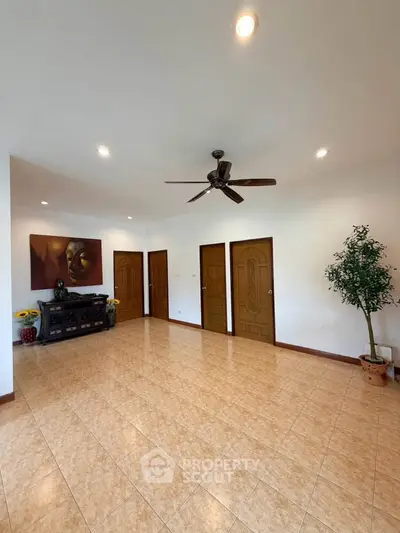 Spacious living room with ceiling fan and elegant decor, perfect for relaxation and entertainment.