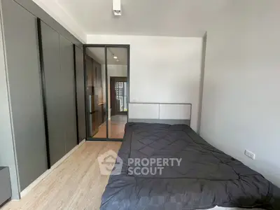 Modern bedroom with sleek design and glass partition, featuring a cozy bed and stylish flooring.