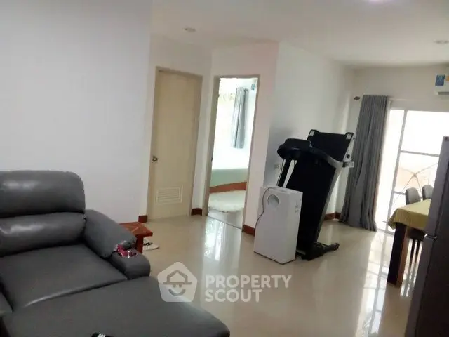 Spacious living room with modern furniture and exercise equipment, perfect for a comfortable lifestyle.