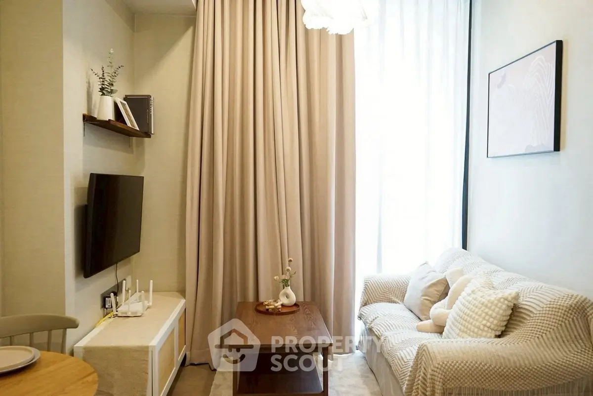 Cozy living room with modern decor, featuring a comfortable sofa, wall-mounted TV, and elegant curtains.