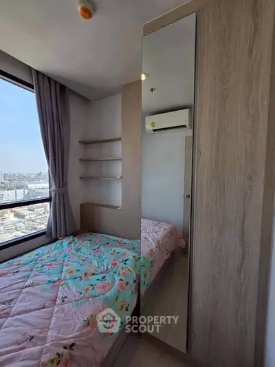 Cozy bedroom with city view, mirrored wardrobe, and air conditioning in modern apartment.