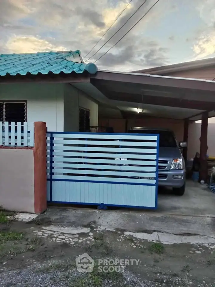 Charming suburban home with carport and modern gate in a peaceful neighborhood.