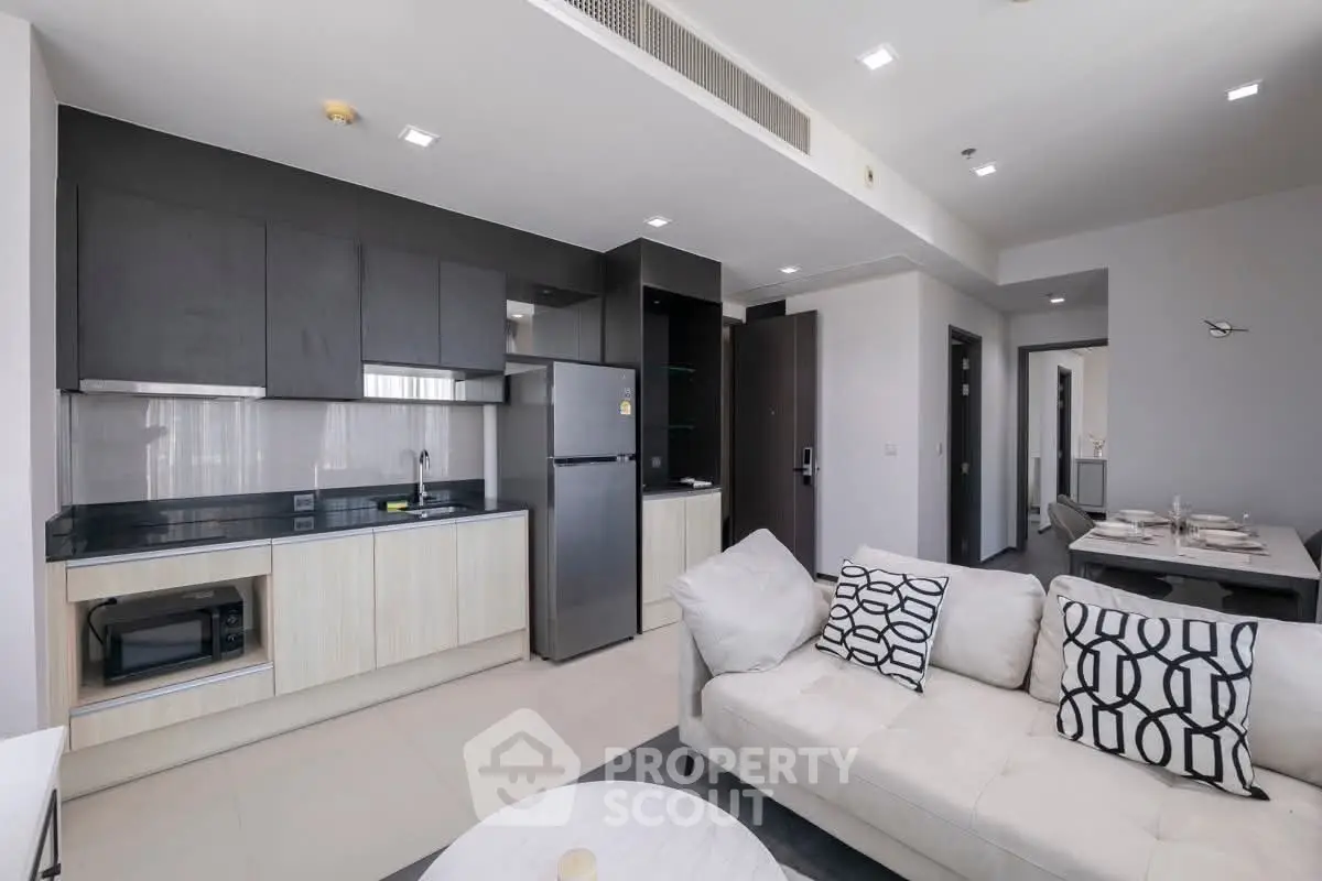 Modern open-plan living room and kitchen with sleek design and stylish furnishings.