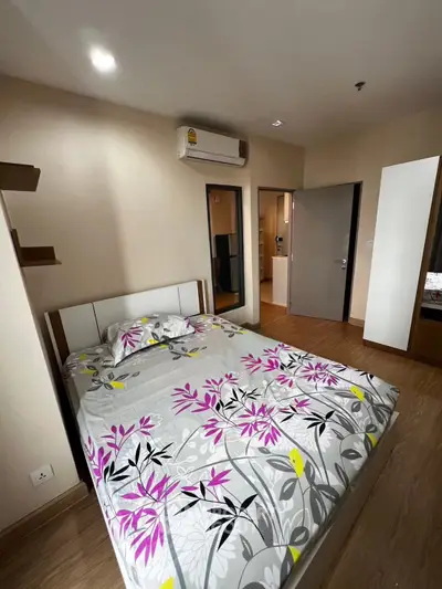 Cozy bedroom with floral bedding and modern air conditioning unit, perfect for restful nights.
