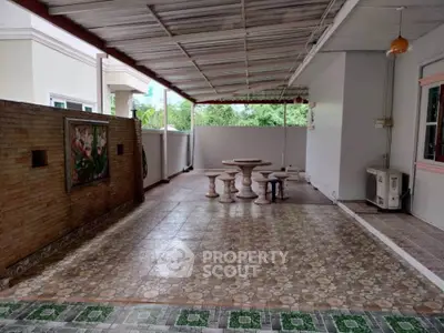 Spacious covered patio with decorative tiles and outdoor seating, perfect for relaxation and entertainment.