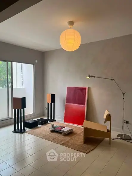 Modern living room with minimalist decor and large window for natural light.