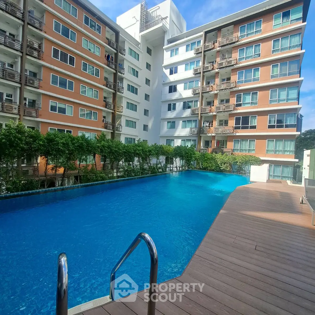 Modern apartment complex with a stunning outdoor pool and lush greenery, perfect for relaxation and leisure.