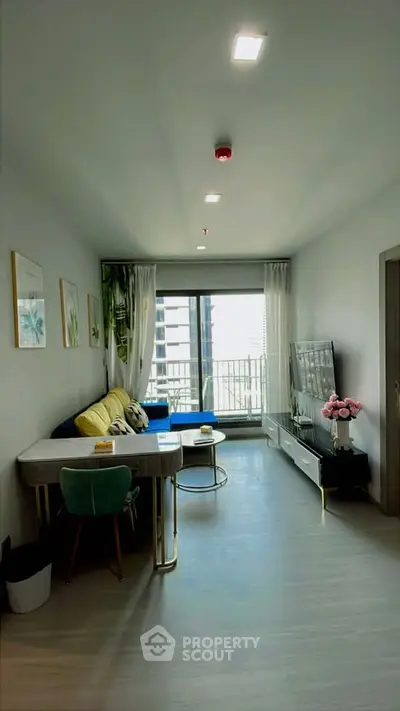 Modern living room with stylish decor and large window offering city view.
