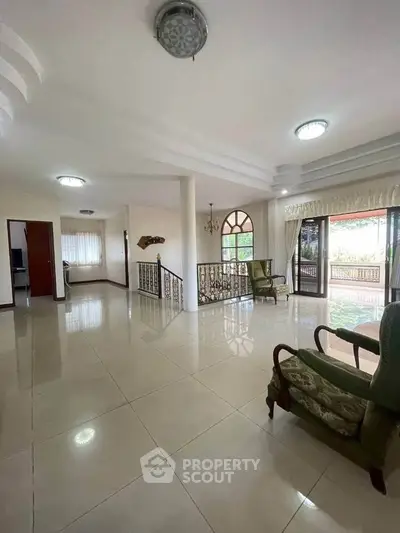 Spacious living room with elegant decor and large windows offering garden views.