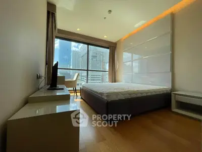 Modern bedroom with large window offering stunning city view, featuring sleek furniture and ambient lighting.
