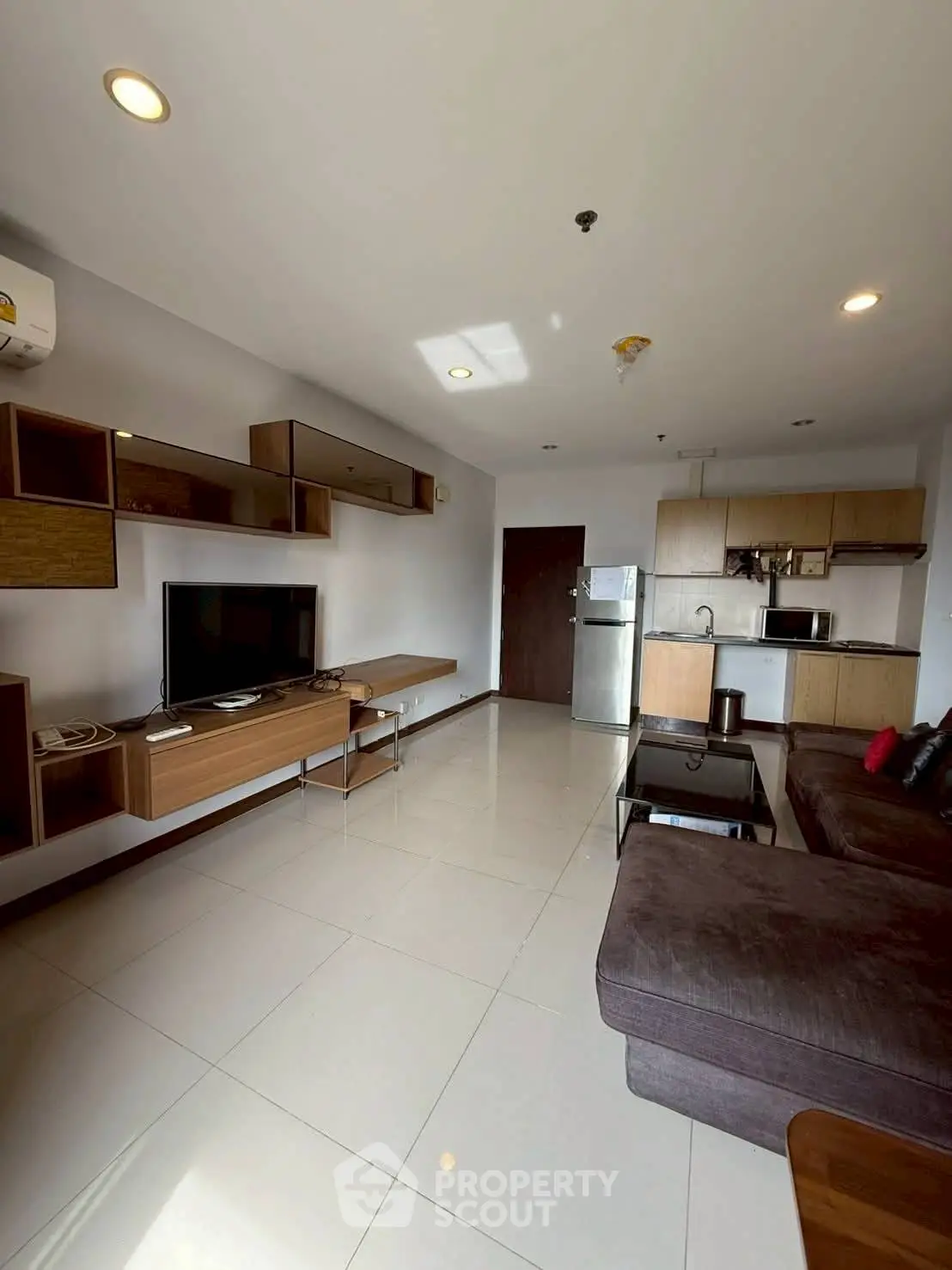 Modern living room with sleek furniture and open kitchen layout in a stylish apartment.