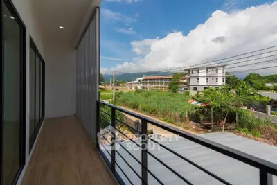 Spacious balcony with scenic view of lush greenery and modern buildings.