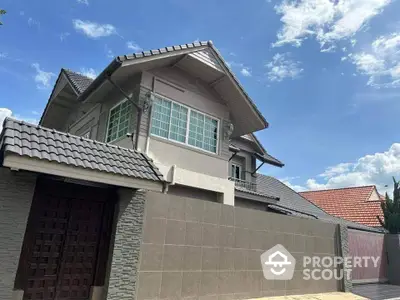 Stunning modern house exterior with tiled roof and spacious driveway under a clear blue sky.