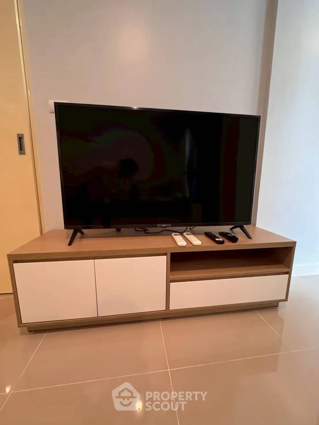 Modern living room with sleek TV stand and large flat-screen TV, perfect for entertainment.
