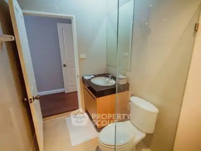 Modern bathroom with glass shower and sleek vanity in a contemporary home.