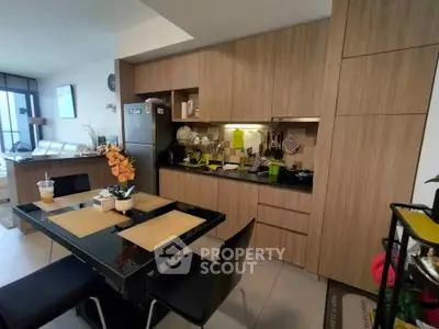 Modern kitchen with sleek cabinetry and dining area in open layout apartment