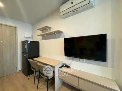 Modern apartment interior with sleek furniture, wall-mounted TV, and air conditioning.
