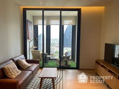 Elegant living room with natural light, modern furniture, and access to a cozy balcony with a city view, perfect for urban living.