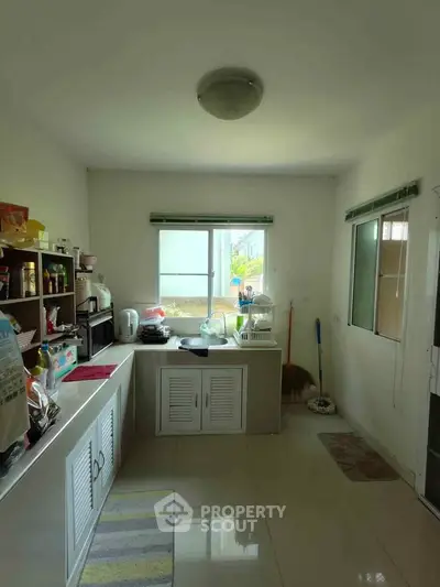 Bright kitchen with ample storage and natural light, featuring modern appliances and sleek design.