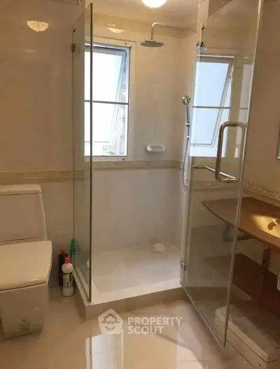 Modern bathroom with glass shower enclosure and sleek fixtures