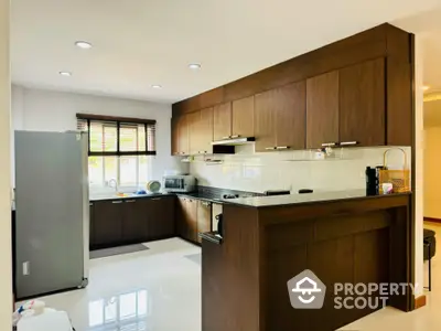 Modern kitchen with sleek wooden cabinets and ample natural light