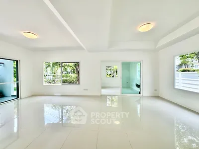 Spacious modern living room with large windows and glossy tile flooring